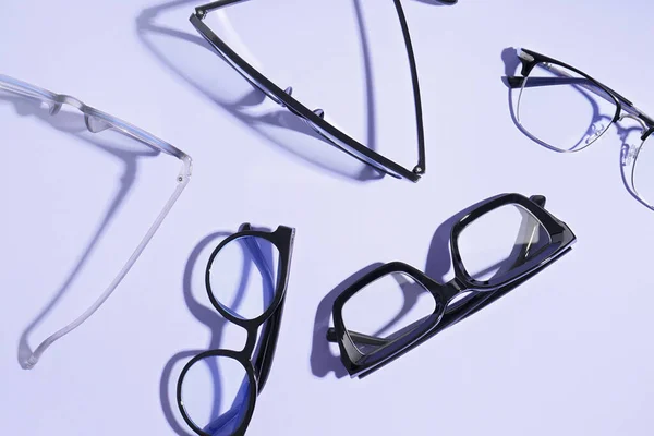 Gafas Nuevas Diferentes Sobre Fondo Púrpura Pálido — Foto de Stock