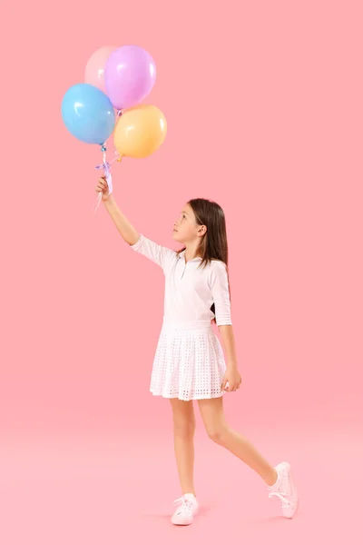 Pembe Arka Planda Balonları Olan Küçük Bir Kız Çocuk Bayramı — Stok fotoğraf