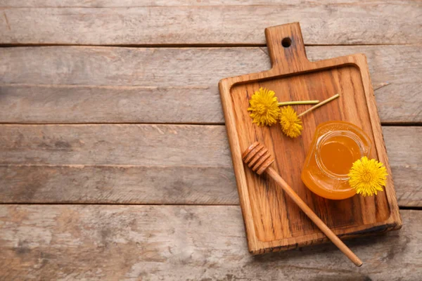 stock image Board with jar of dandelion honey on wooden background