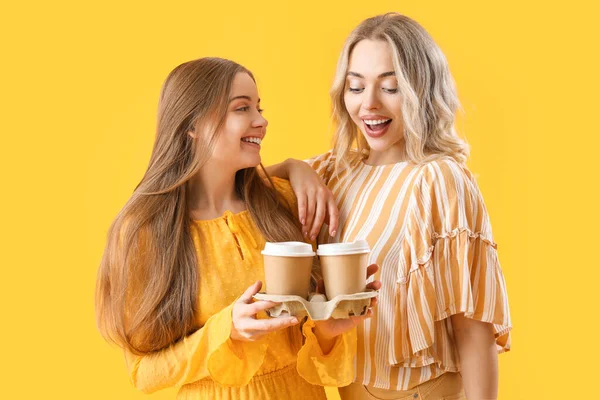 Jonge Zussen Met Kopjes Koffie Gele Achtergrond — Stockfoto