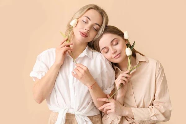 Junge Schwestern Mit Tulpen Auf Beigem Hintergrund — Stockfoto