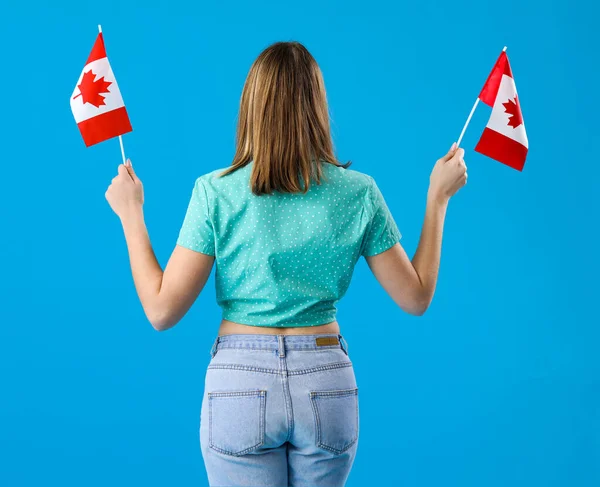 Ung Kvinna Med Flaggor Kanada Blå Bakgrund Baksida Visa — Stockfoto