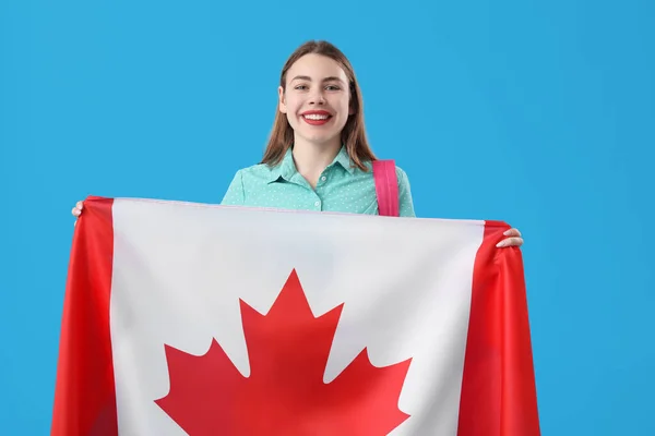 身穿蓝色背景加拿大国旗的年轻女子 — 图库照片
