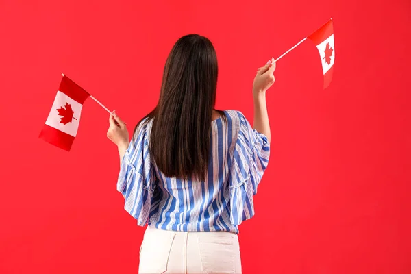 Jonge Vrouw Met Vlaggen Van Canada Rode Achtergrond Achteraanzicht — Stockfoto