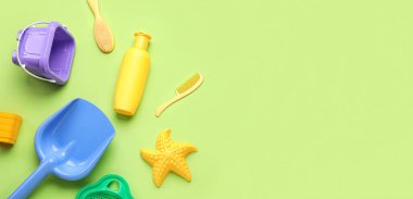 Yeşil arka plandaki çocuklar için güneş kremi ve plaj aksesuarları.
