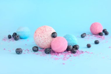 Açık mavi zemin üzerinde yaban mersinli ve deniz tuzlu banyo bombası