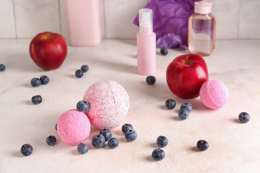 Banyo bombaları, meyveler ve kozmetik şişelerle aydınlatma masasında kompozisyon
