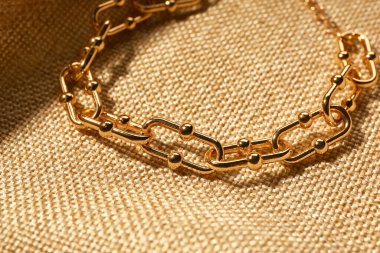 Bej kumaş arka planda güzel bir zincir bilezik