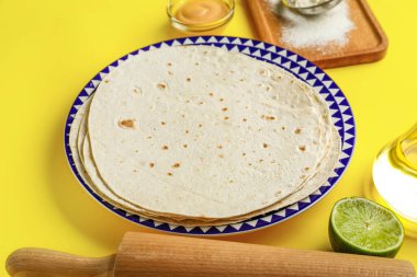 İnce lavaşlı tabak ve sarı arka planda malzemeler.