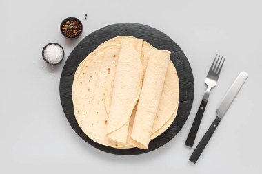 Gri arkaplanda tuz ve biberli ince lavaş tahtası.