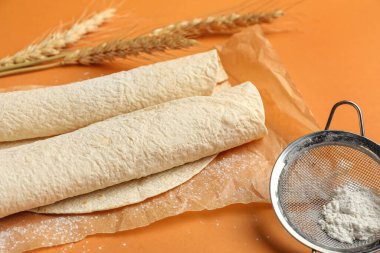 Turuncu arka planda ince lavaşlı fırın kağıdı