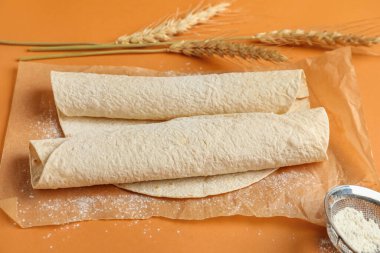 Turuncu arka planda ince lavaşlı fırın kağıdı