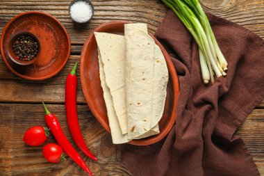 Ahşap arka planda taze lavaş ve sebzeli tabak.