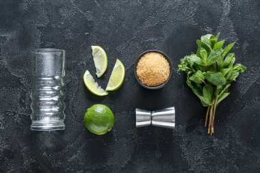 Koyu arkaplanda mojito hazırlamak için cam, ölçü ve malzeme.