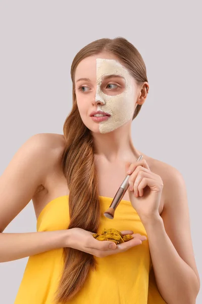 Young Woman Applied Turmeric Mask Brush Roots Grey Background — Stock Photo, Image