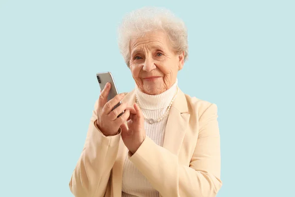 Старшая Женщина Помощью Мобильного Телефона Синем Фоне — стоковое фото