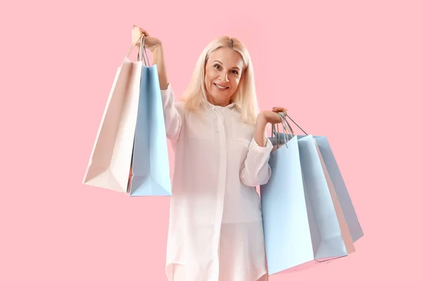Dojrzała Kobieta Papierowymi Torbami Różowym Tle Zakupy Online — Zdjęcie stockowe