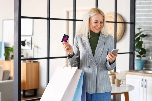 Gammal Kvinna Med Mobiltelefon Kreditkort Och Shoppingväskor Hemma — Stockfoto