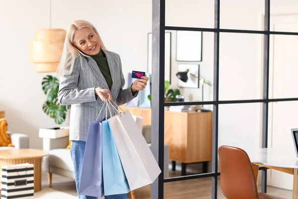Volwassen Vrouw Met Credit Card Boodschappentassen Praten Mobiele Telefoon Thuis — Stockfoto