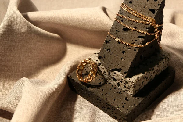Decorative Podium Beautiful Chain Necklace Ring Beige Fabric Background — Stock Photo, Image