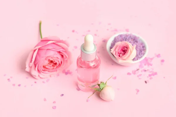 Fles Cosmetische Olie Met Roos Extract Bloemen Roze Achtergrond — Stockfoto