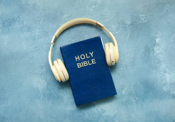 stock image Holy Bible with headphones on blue background