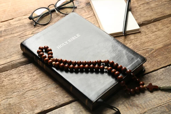 stock image Holy Bible and prayer beads on wooden background