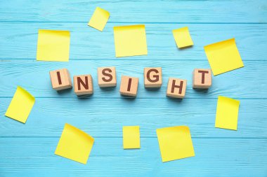 Ahşap küplerden ve mavi ahşap arka planda yapışkan kağıtlardan oluşan bir kelime.