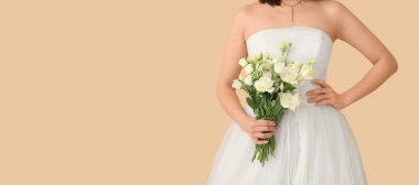 Bej arka planda bir buket östoma çiçeğiyle, metin için yeri olan güzel bir gelin.