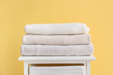 Odada bej duvarın yanında güzel kazaklı raf ünitesi var.