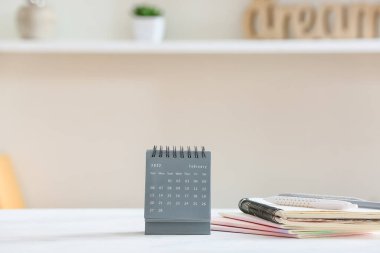 Şubat ayı için kağıt takvime ve masadaki defterlere bak.