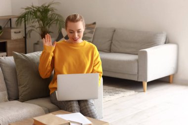 Evde dizüstü bilgisayarla çalışan kız öğrenci.