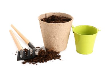 Topraklı, kovalı, kürekli ve beyaz arkaplanlı turba tenceresi.