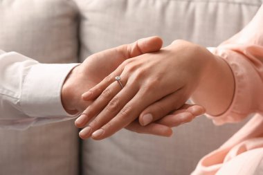 Nişanlı çift el ele tutuşuyor, yakın çekim.