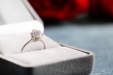 Mavi arkaplanda nişan yüzüğü olan kutu, yakın plan.