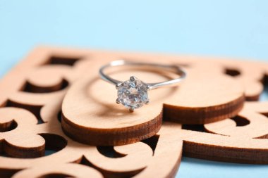 Mavi arka planda tahta kalpli gümüş nişan yüzüğü, yakın plan.