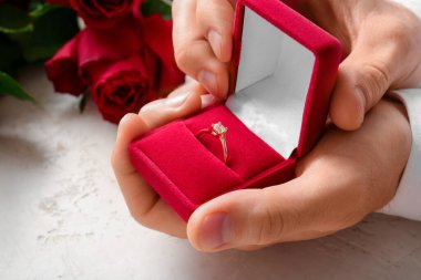 Beyaz arka planda nişan yüzüğü olan bir adam, yakın plan.