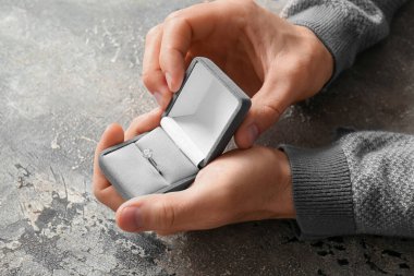 Grunge arka planında nişan yüzüğü olan bir adam.