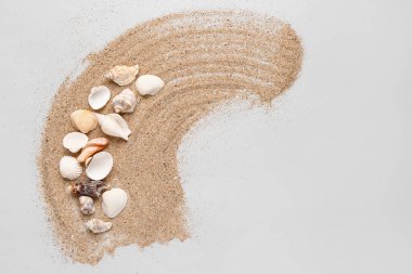 Gri arka planda deniz kabukları olan kum damlası