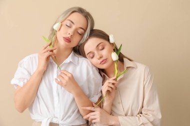 Bej arka planda laleleri olan genç kardeşler.