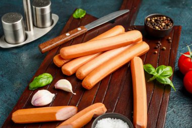 Arka planda fesleğenli ve sarımsaklı lezzetli sosisler.