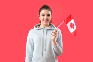 Kırmızı arka planda Kanada bayrağı olan genç bir kadın