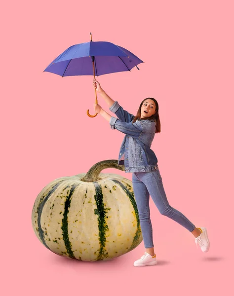 Unruhige Junge Frau Mit Regenschirm Und Großem Kürbis Auf Rosa — Stockfoto