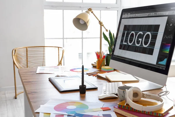 stock image Graphic designer's workplace with computer, tablet and paint palettes in office