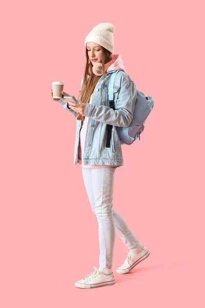 Kobieta Filiżanką Kawy Przy Użyciu Telefonu Komórkowego Różowym Tle — Zdjęcie stockowe