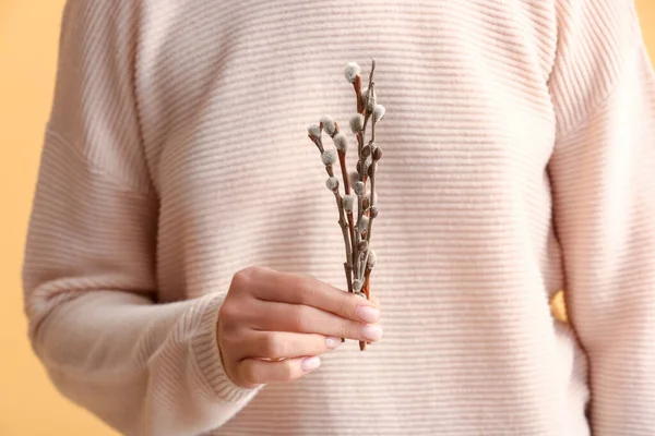 stock image Woman with willow branches on yellow background, closeup