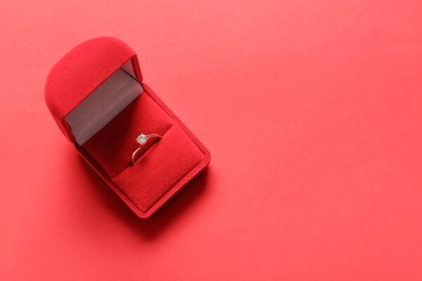 Box with engagement ring and red background