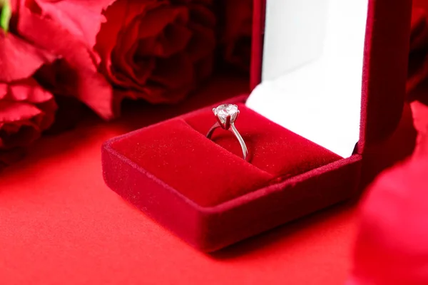 Box Mit Verlobungsring Und Rosen Auf Rotem Hintergrund — Stockfoto