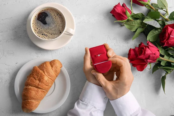 stock image Man with engagement ring, coffee, croissant and roses on white background