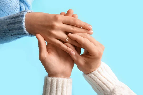 Homem Colocando Anel Noivado Dedo Mulher Contra Fundo Azul Close — Fotografia de Stock